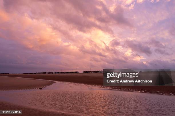 Winter sunset red sky over the long sandy beach of Sutton on Sea, Lincolnshire. United Kingdom. Sutton on Sea is on the coast of the North Sea, and...