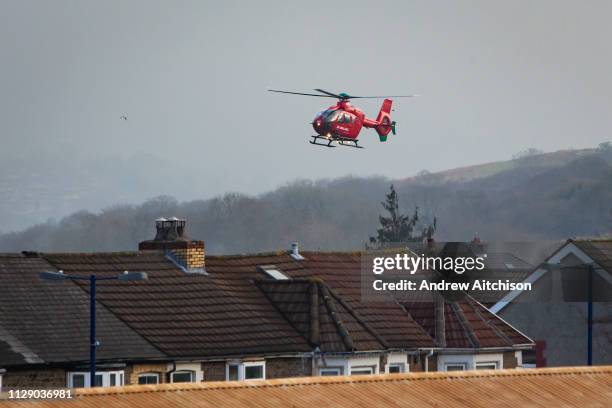 Welsh Air Ambulance Helicopter arrives over the roof tops into Caerphilly to attend to a patient. Caerphilly, South Wales. Wales Air Ambulance...