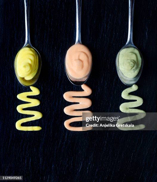 vegan almonds mayonnaise with wasabi, chilli and turmeric in bowl on black background. dairy, egg and soy-free. - suaces stock pictures, royalty-free photos & images