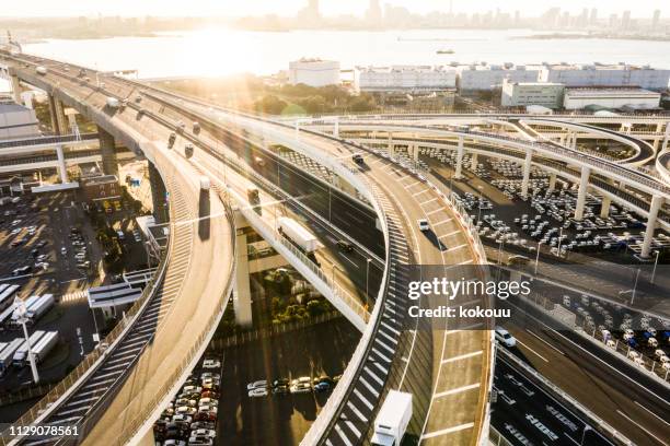 海に向かって高速道路。夕日に照らされた高架道路。逆光で写真を撮る。 - multiple lane highway ストックフォトと画像