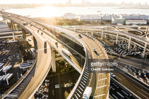 highway towards the sea. an elevated road illuminated by the sunset. take pictures with backlight. - highways stock pictures, royalty-free photos & images