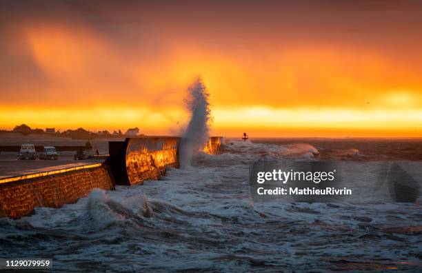 sunrise and powerful storm against the coast and the harbor - phénomène climatique extrême fotografías e imágenes de stock