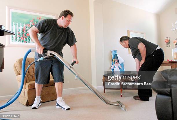 Doug Kelley, left, and his father Jay Kelley, clean the carpet of a home in Roseville, California, April 17, 2008. Kelley, who owns carpet-cleaning...