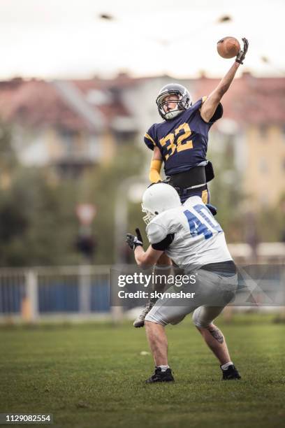 het vangen van de bal op american football wedstrijd! - wide receiver atleet stockfoto's en -beelden
