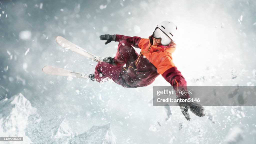 Young woman and winter sport - she is skiing against white alps mountains