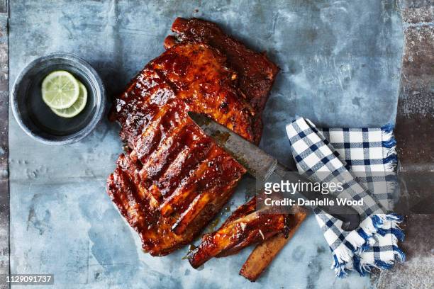 still life with bbq spare ribs and kitchen knife, overhead view - sparerib stock pictures, royalty-free photos & images