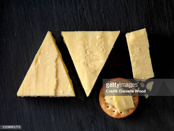 still life with cheese cracker and cheddar cheese triangles on black slate, overhead view - cheese stock pictures, royalty-free photos & images