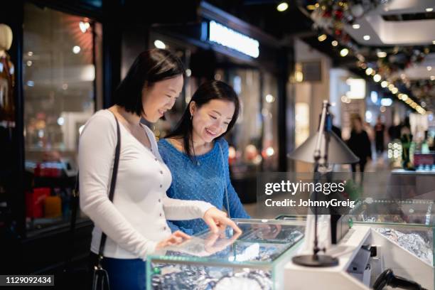 freunde im einkaufszentrum auf vitrine - tsim sha tsui stock-fotos und bilder