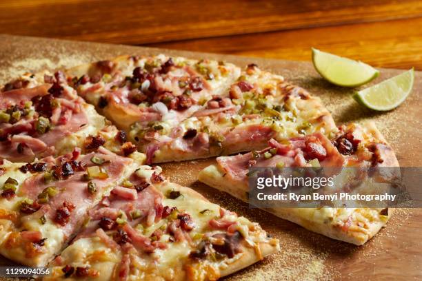 cuban ham & swiss pizza with lime on chopping board - flatbread pizza stock pictures, royalty-free photos & images