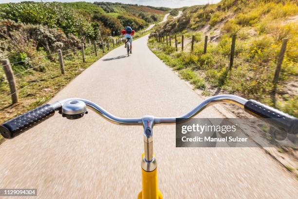 cycling along rural road between dunes near den haag, personal perspective,  scheveningen, south holland, netherlands - south holland ストックフォトと画像