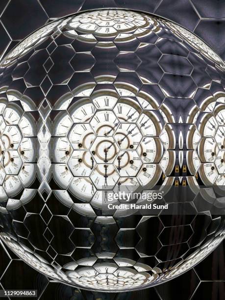 distorted appearing vintage antique grandfather clock face with roman numeral numbers and hour and second hands multiply reflected in a hexagon sphere glass shapes. - roman numeral ten stock pictures, royalty-free photos & images