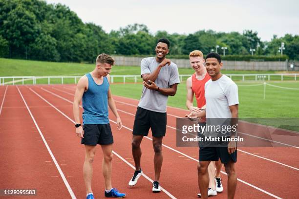 friends talking on running track - track and field stadium stock pictures, royalty-free photos & images