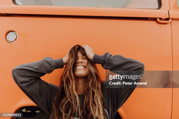 young woman in front of orange recreational vehicle at beach, portrait, jalama, california, usa - long hair stock pictures, royalty-free photos & images