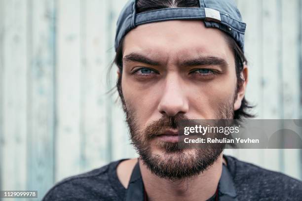 man with stubble wearing cap back to front - de atrás hacia adelante fotografías e imágenes de stock