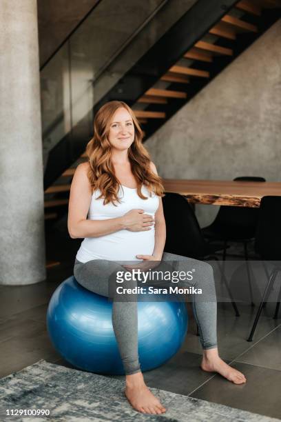 pregnant woman on exercise ball - pregnant redhead ストックフォトと画像