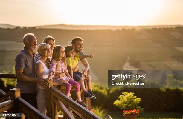 happy erweitert familie genießen auf der terrasse bei sonnenuntergang. - extended family outdoors spring stock-fotos und bilder