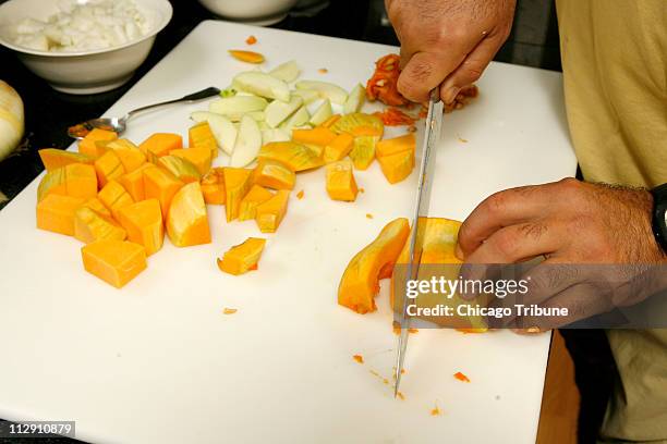 Chef Erwin Dreschler slices a squash for butternut squash and apple cider soup at his home on Wednesday, September 3 in Winnetka, Illinois.
