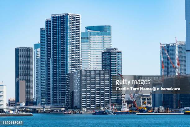 tokyo bay and residential buildings on tsukishima pier and harumi pier in chuo ward of tokyo in japan - harumi district tokyo stock pictures, royalty-free photos & images