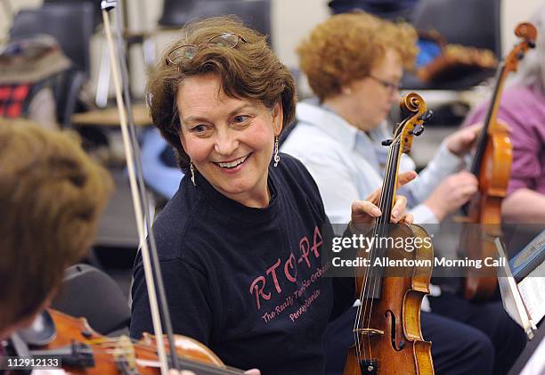 Colleen Schoneveld, of Nazareth, facing camera, founder and leader of "The Really Terrible Orchestra - PA," jokes with fellow violinist Kay Ritter,...