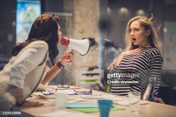 boos vrouwelijke leider schreeuwen tegen haar collega via megafoon. - bazig stockfoto's en -beelden