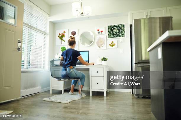 la technologie rend le travail à domicile une brise - femme assise bureau photos et images de collection