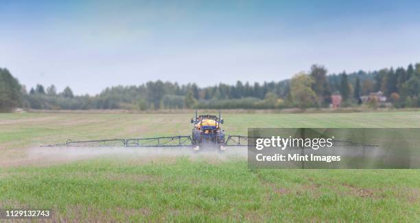 tractor spraying herbicide - herbicide spraying stock pictures, royalty-free photos & images