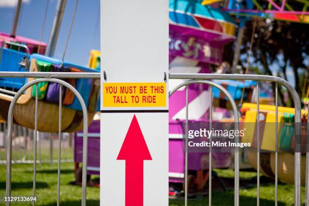height requirement sign in front of amusement park ride - height foto e immagini stock