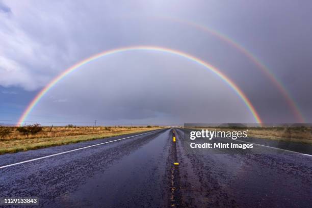 rainbow on a rural road - dubbel regnbåge bildbanksfoton och bilder