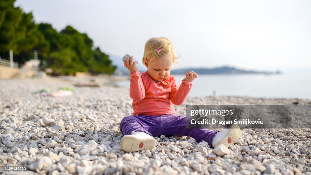 Baby playing with pebble