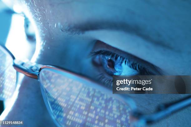 woman with computer screen reflecting in glasses - computer screen reflection stock pictures, royalty-free photos & images