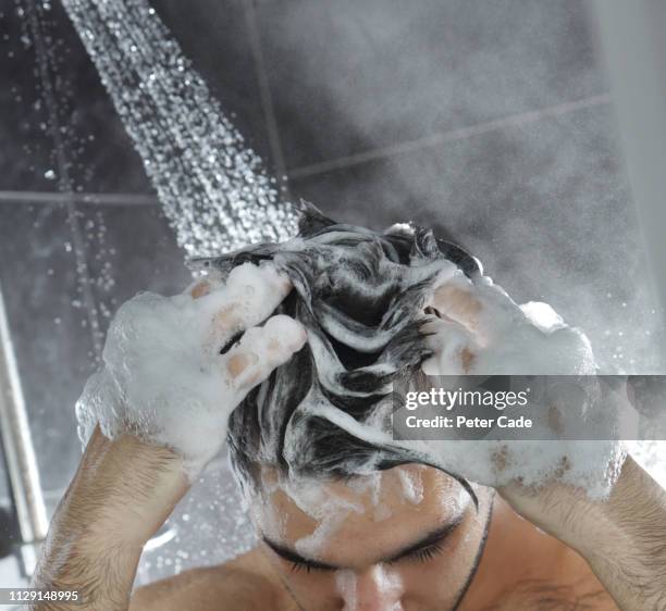 man in shower washing hair - shampoo stockfoto's en -beelden