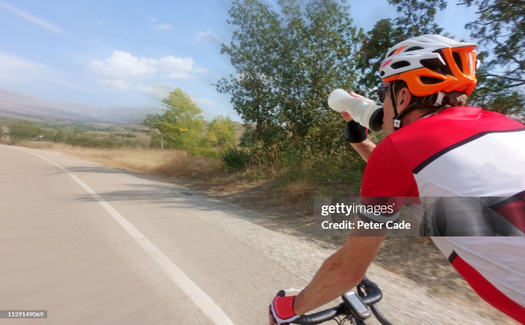 Man drinking from water bottle while cycling
