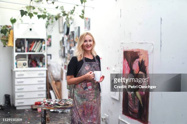 een vrouw in haar kunstatelier aan huis schilderen. - hobbys stockfoto's en -beelden