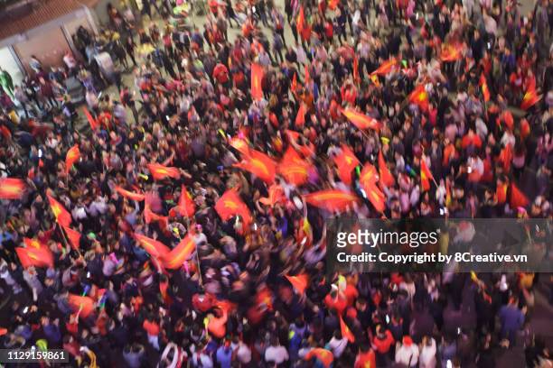 crowd of vietnamese football fans down the street to celebrate the win after vietnam team won in aff cup 2018, with a lot of vietnamese flags raising high. - political party foto e immagini stock