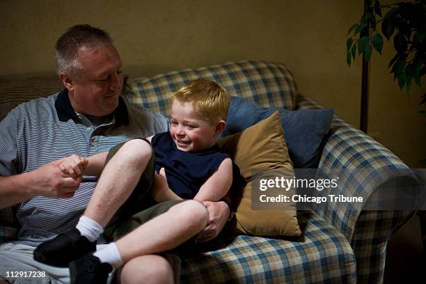 Frank Osowski, left, plays with his son Ben at their home in Mokena, Illinois, on June 12, 2008. Ben suffers from epidermolytic hyperkeratosis, or...