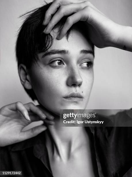 young woman posing against white wall - androgynous stock pictures, royalty-free photos & images