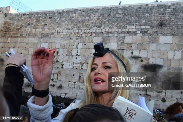 Member of the liberal Jewish religious movement "Women of the Wall" wearing "Tefillin" or phylacteries , and "Tallit" , prays during an event marking...