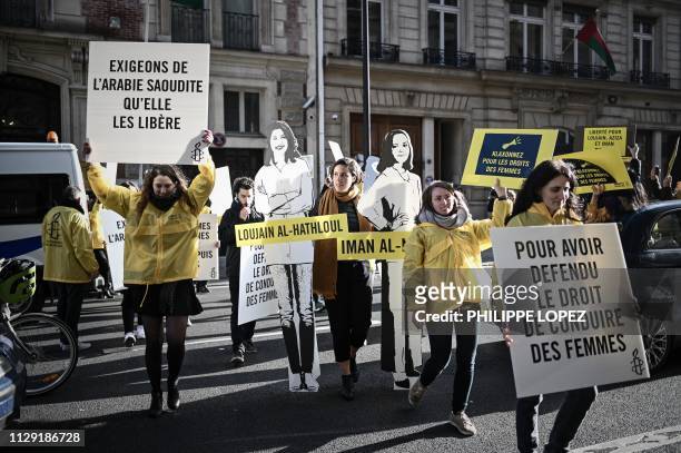 Women's rights activists hold signs as they take part in a demonstration organized by Amnesty International outside the Saudi Arabia embassy in...