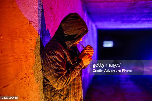 kriminellen drug addict rauchen drogen in unterirdischen tunnel - smoking crack stock-fotos und bilder