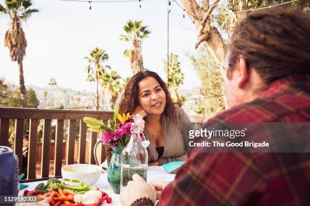 man and woman having discussion at family party - los angeles garden party stock pictures, royalty-free photos & images