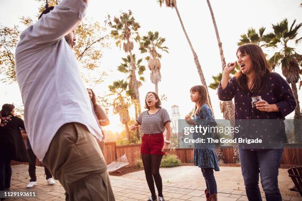 family dancing together on deck in backyard - los angeles garden party stock pictures, royalty-free photos & images