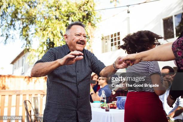 senior man dancing with wife at family party - social action party stock pictures, royalty-free photos & images