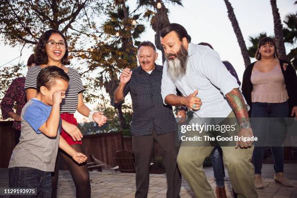 multi-generation family dancing in backyard - los angeles events stock-fotos und bilder