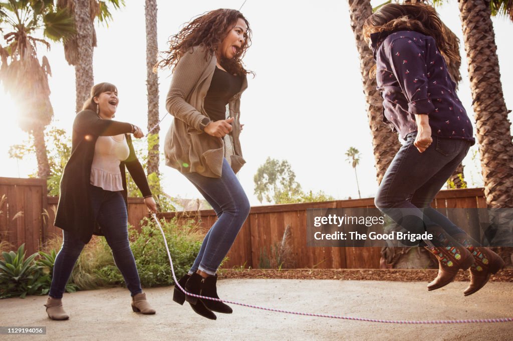 Mature adult women jumping rope in backyard