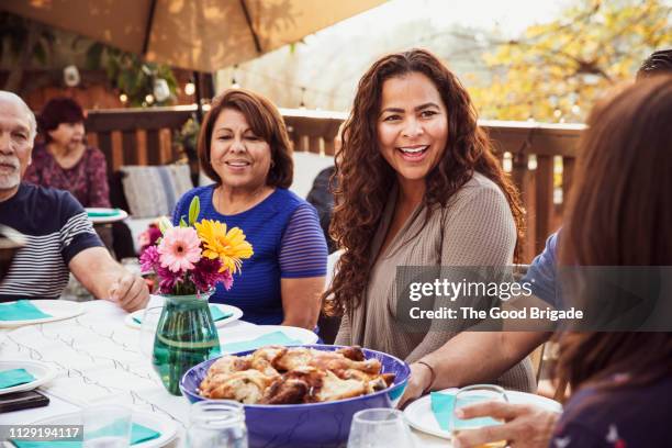 family laughing together during outdoor dinner party - bbq chicken stock-fotos und bilder