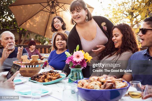 teenage girl serving food to family at outdoor celebration - outdoor party imagens e fotografias de stock