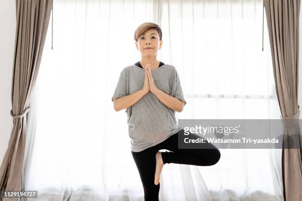 Thai middle-aged woman enjoys yoga at home