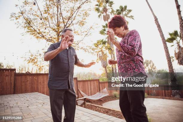 Senior couple dancing in backyard at party