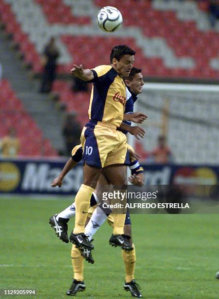 Hugo Norberto Castillo , of the American soccer team, fights for the ball against Santiago del Sonio, of the Talleres de Cordoba de Argentina during...