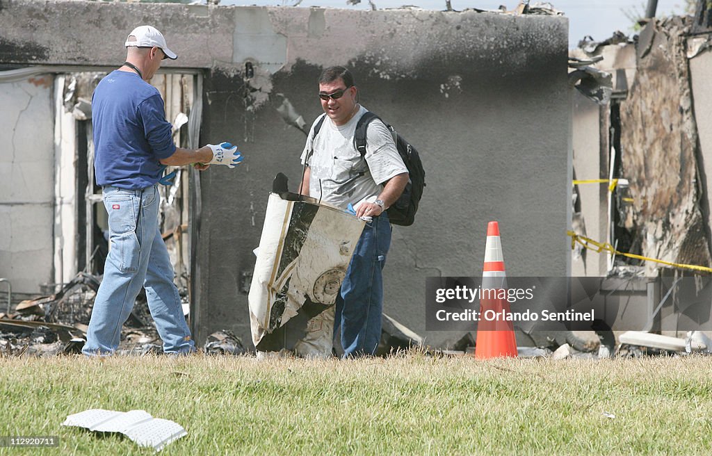NTSB inspectors pick through airplane parts, Wednesday, July